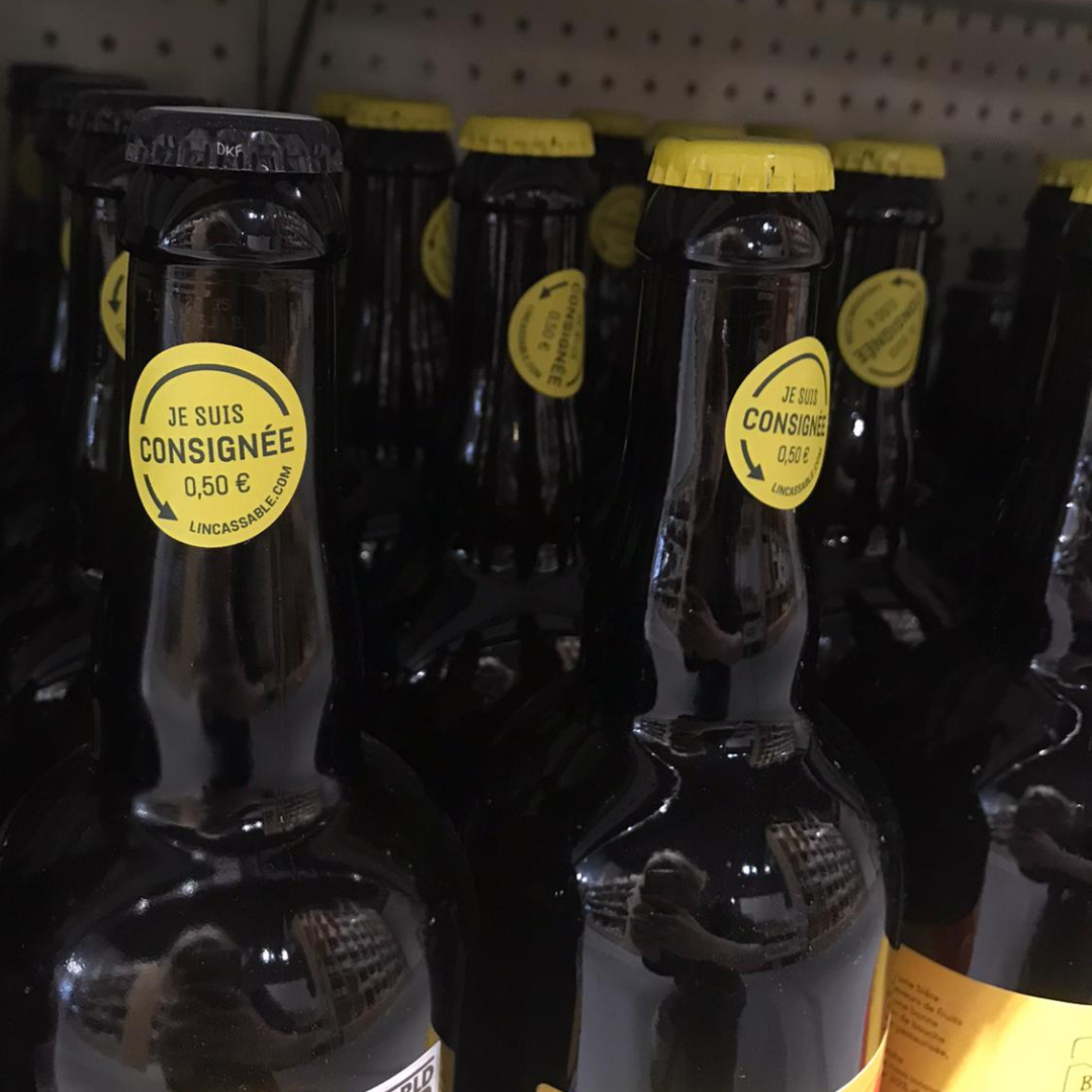 Bouteilles situées dans les rayon d'un magasin bio. Ces bouteilles sont consignées par L'INCASSABLE, un opérateur de réemploi de bouteilles en verre.